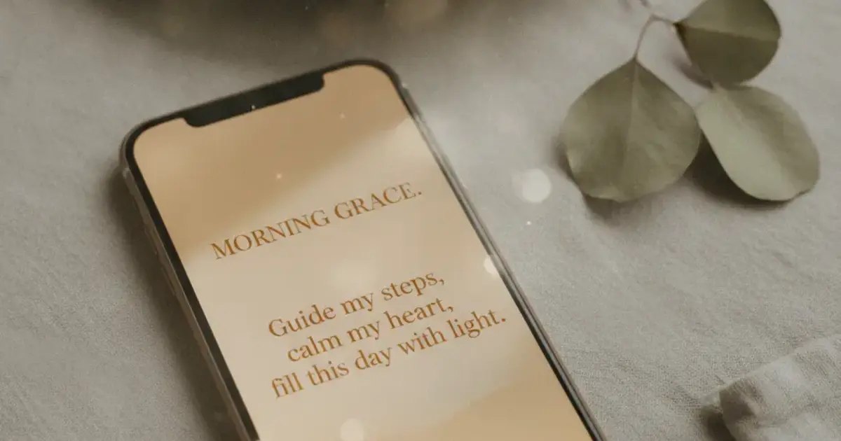 Phone screen showing an AI-generated prayer on a warm amber background with soft morning light